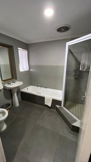A bathroom with a sink, bathtub, and toilet. - Mountainview Inn (Maluti a Phofung)
