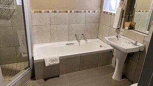 Un baño con bañera, lavamanos y retrete.