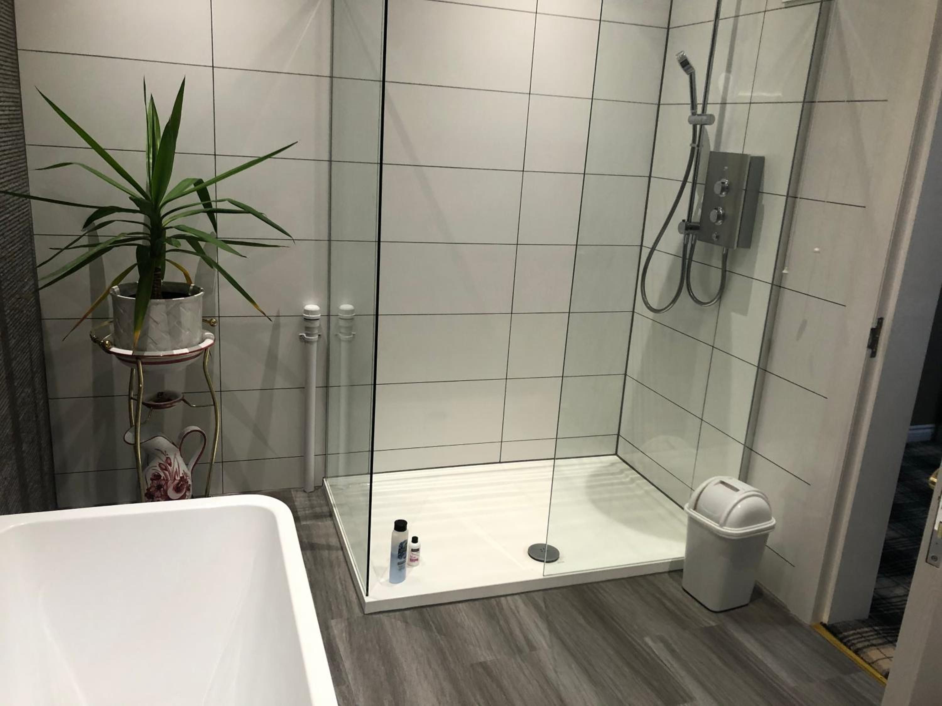 A modern bathroom with a shower, a toilet, and a bathtub.
