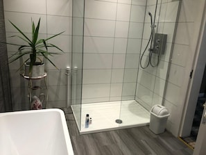 Un baño moderno con ducha, inodoro y bañera.
