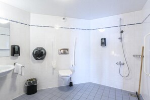 Uma casa de banho moderna com sanita, bidé e chuveiro.