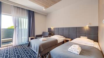 A hotel room with two beds, a balcony, and a modern design.