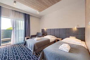Habitación de hotel con dos camas, un balcón y un diseño moderno.