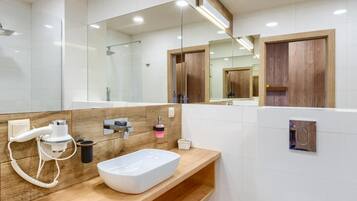 A modern bathroom with a wooden vanity, a white sink, and a toilet.