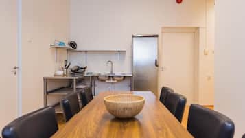 A compact kitchen with a stainless steel refrigerator, a sink, and a small countertop.