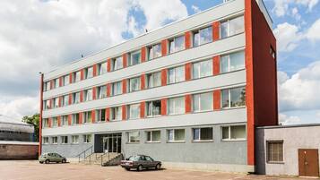A multi-story building with a parking lot in front.