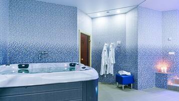 Ein Badezimmer mit einer großen Badewanne, einer Dusche und einer blauen Mosaikwand.