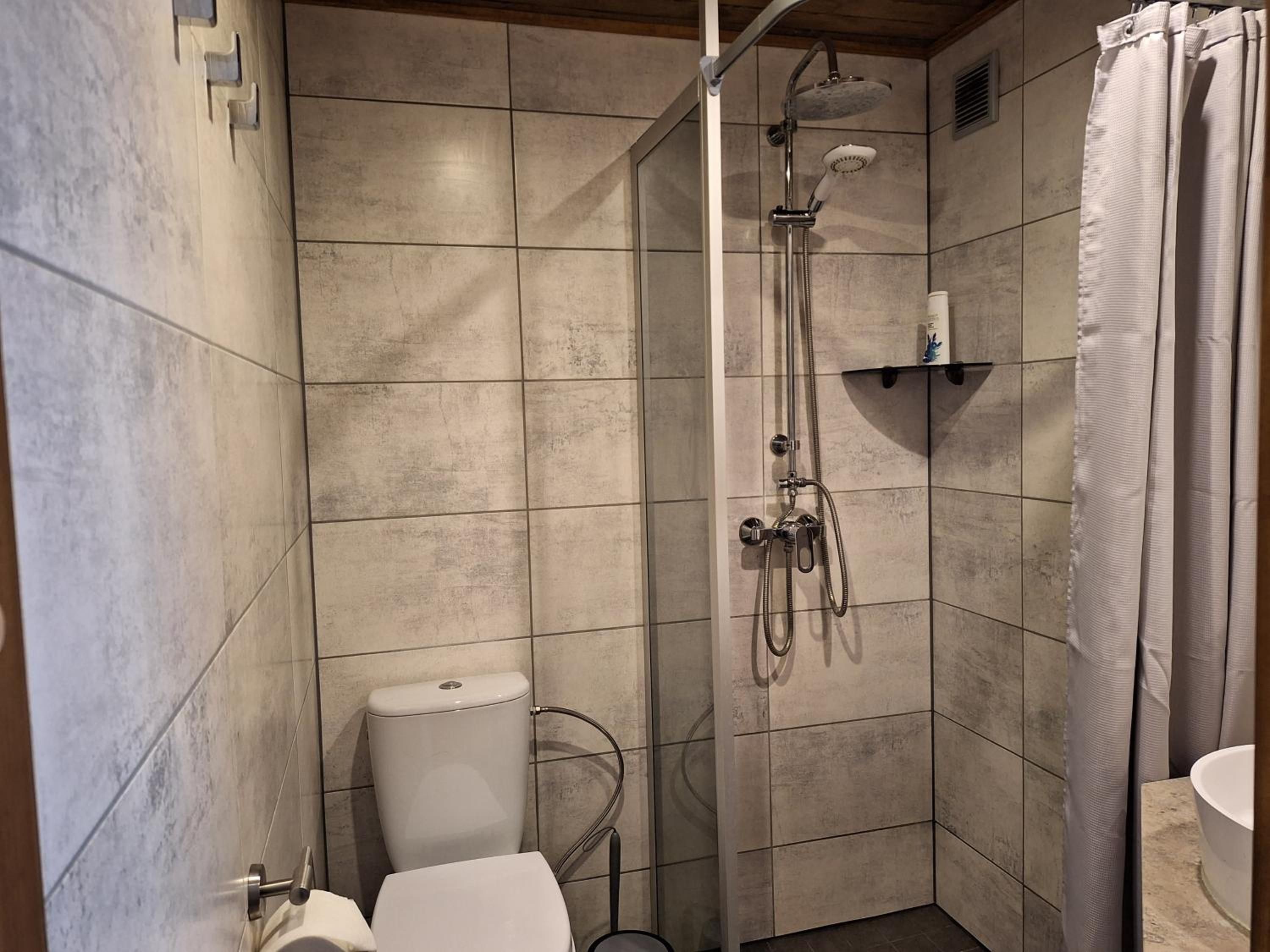 Un baño con ducha, inodoro y lavamanos.