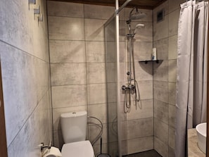 Un baño con ducha, inodoro y lavamanos.