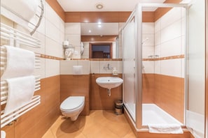 A bathroom with a toilet, sink, and shower.