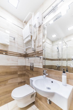 A modern bathroom with a toilet, sink, and shower. - Hotel Doris (Oborniki)