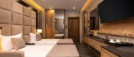 A hotel room with two beds, a large mirror, a flat-screen TV, and a wooden sideboard with a tray.
