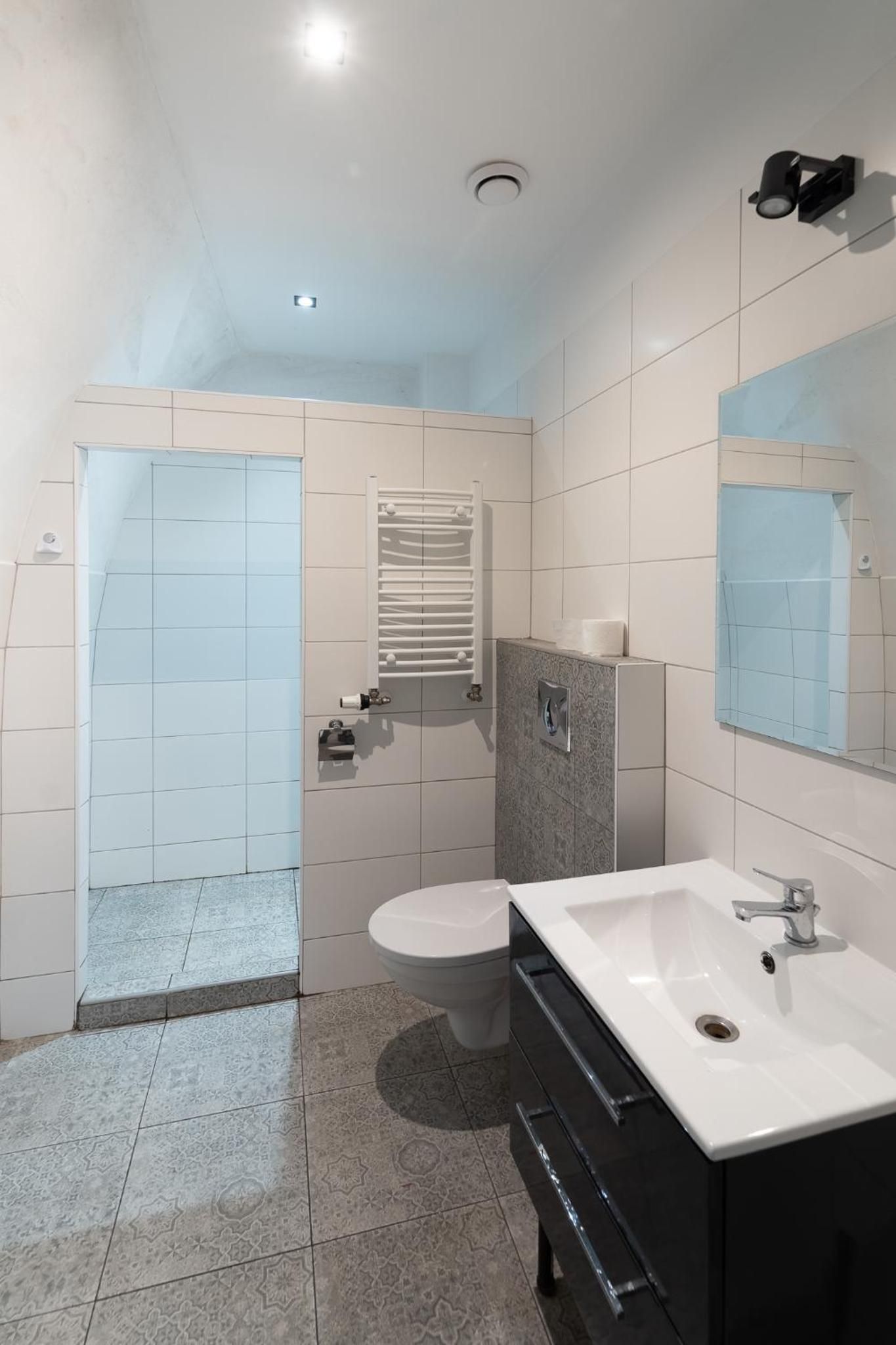 Ein modernes Badezimmer mit Toilette, Waschbecken und Duschbereich.