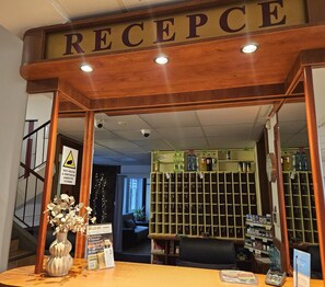 A reception area with a wooden sign that reads 'RECEPCHE'. - Hotel Trim (Pardubice)