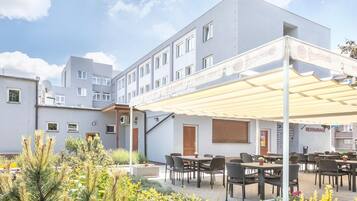 Un hotel con asientos al aire libre y un patio cubierto.