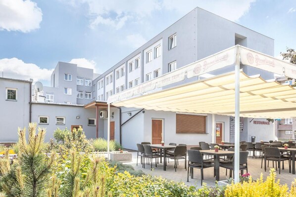 Un hotel con asientos al aire libre y un patio cubierto.