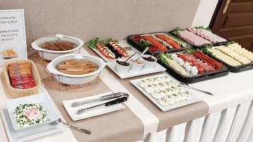 A buffet with various food items including meats, cheeses, and vegetables.