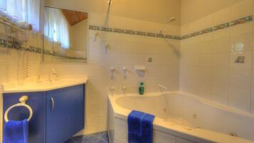 A bathroom with a bathtub, a sink, a mirror, and a towel ring.