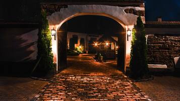 An arched entrance to a building with a cobblestone pathway leading through it.