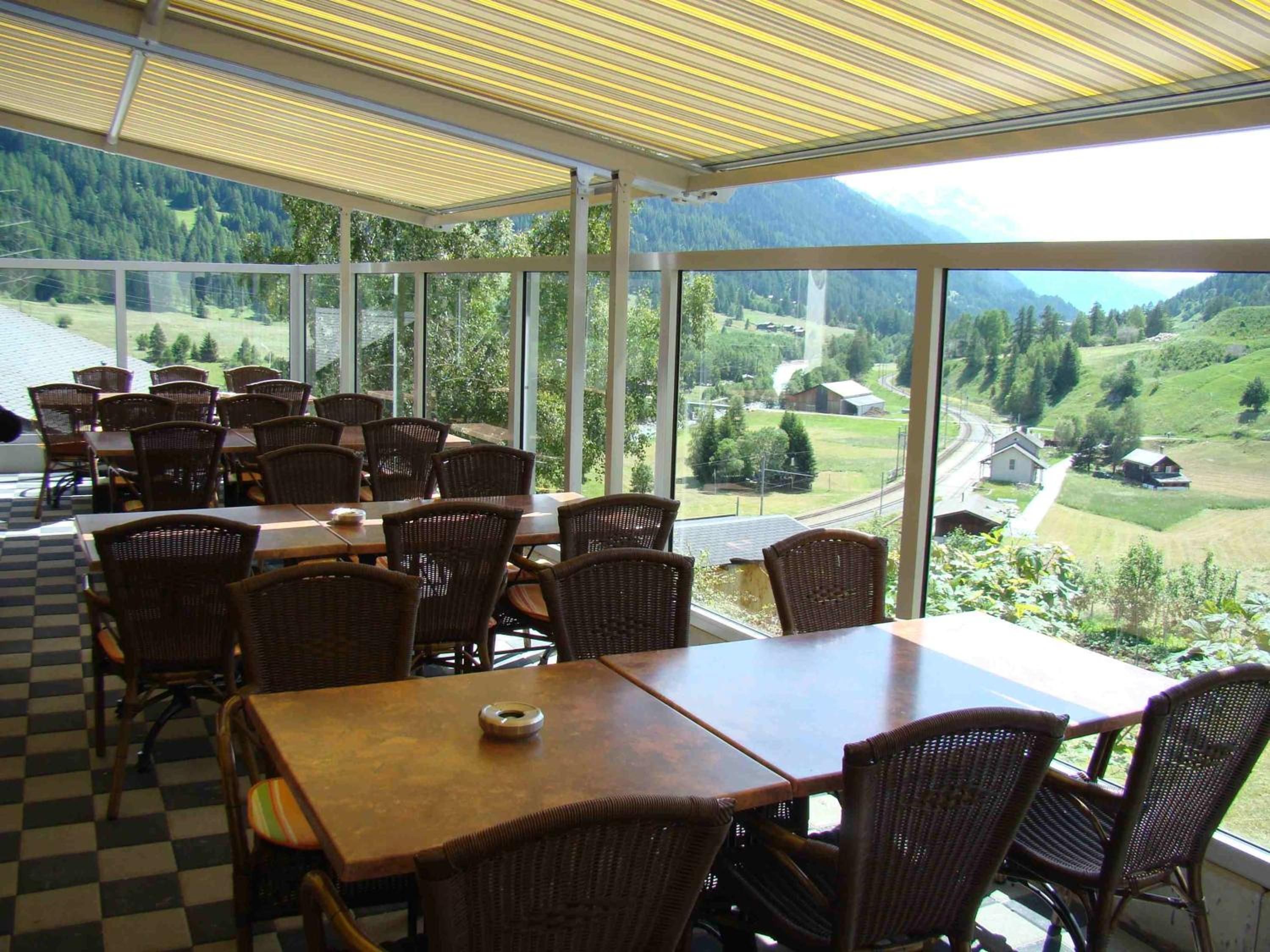 A restaurant with large windows offering a view of a mountainous landscape.