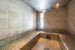 Casa de banho moderna com paredes revestidas de azulejos, um banco e área de duche.
