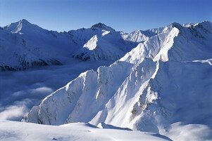 A snow-covered mountain range with sharp peaks and ridges.
