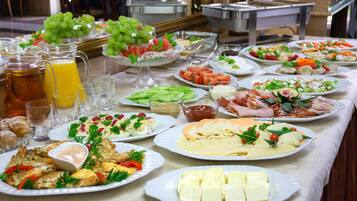 A buffet table with various food items and beverages.