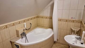 A bathroom with a bathtub, a sink, and a shower curtain.