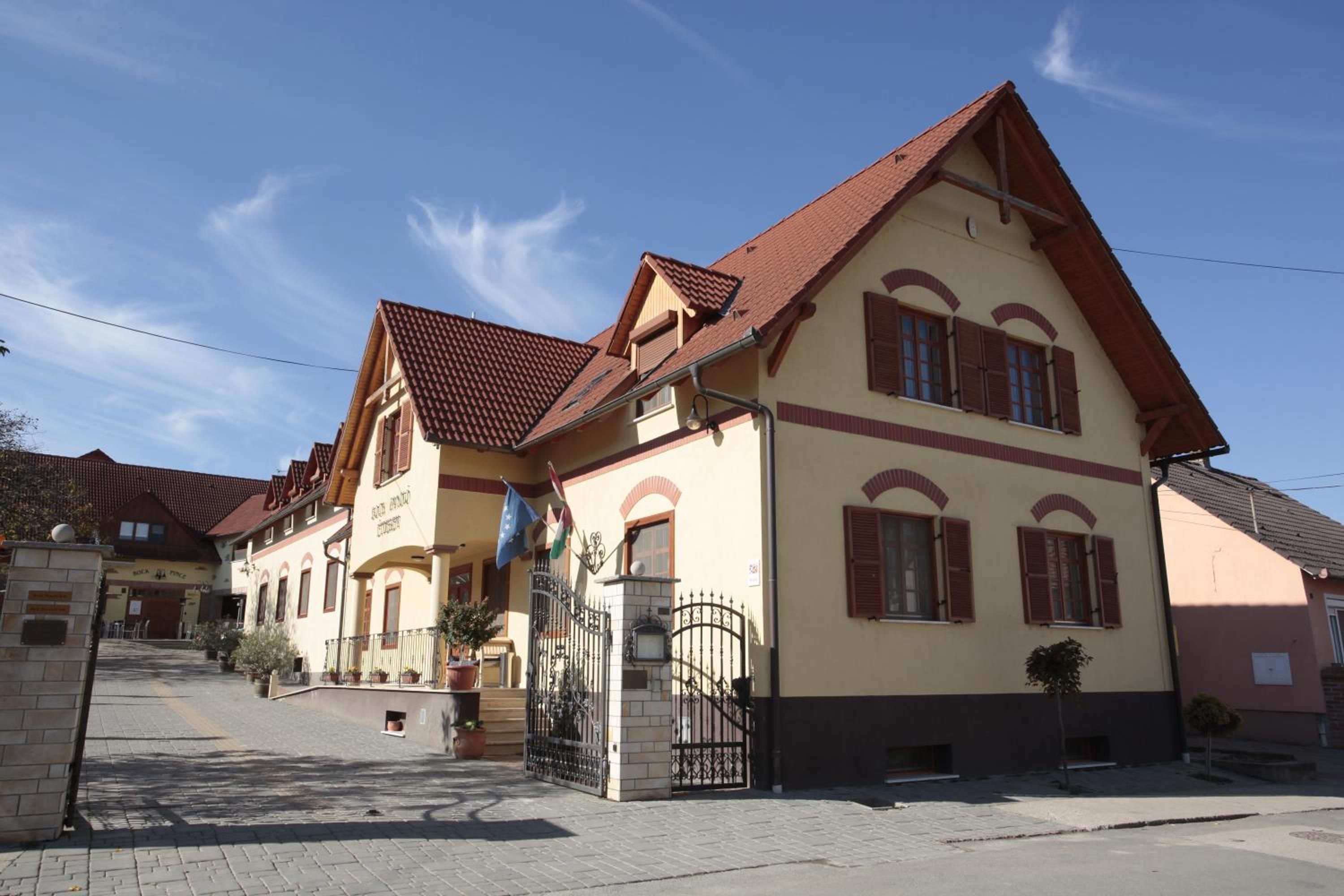 Ein traditionelles Gebäude im europäischen Stil mit Satteldach, zahlreichen Fenstern mit Fensterläden und einem ehrfurchtgebietenden Eingangstor.