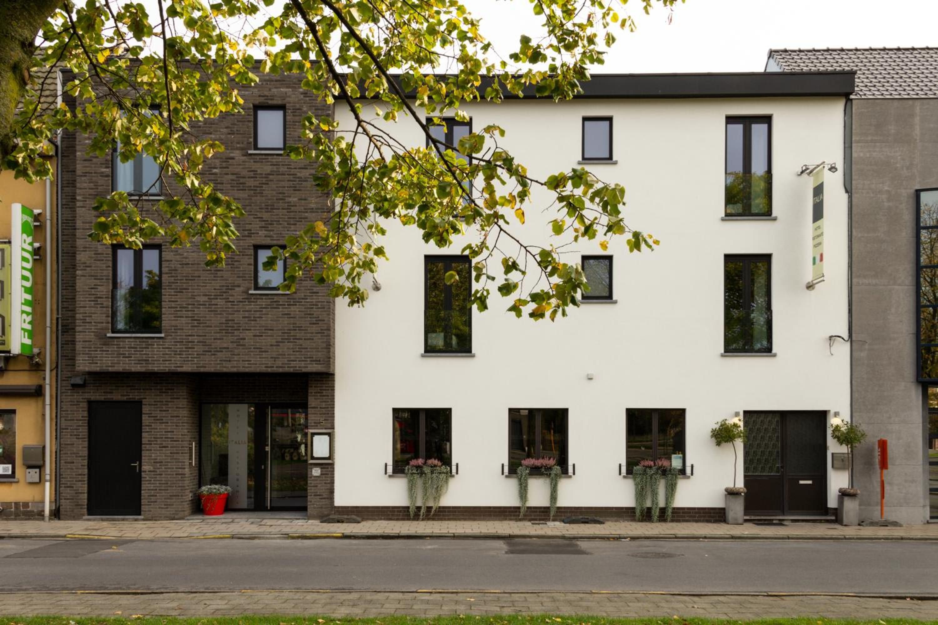 Een gebouw met twee verdiepingen in moderne architectuur, met een plat dak, grote ramen en een strakke gevel.