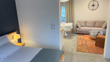 Una habitación de hotel con una cama, un escritorio con una silla, un sofá y una mesa redonda.
