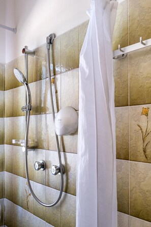 A shower with a handheld showerhead and a wall-mounted faucet. - Aurora Residence (Ravenna)