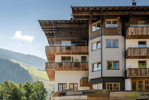 Un hotel de varios pisos con balcones de madera y vistas a las montañas.