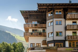 Un hotel de varios pisos con balcones de madera y vistas a las montañas.