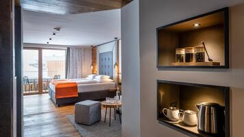 Een moderne hotelkamer met een bed, een eethoek en een kitchenette.
