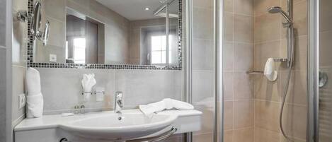 A modern bathroom with a sink, mirror, and shower.