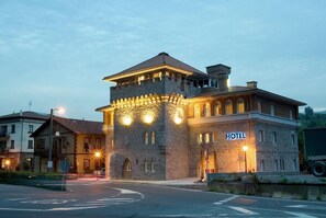 A hotel with a stone facade, a tower, and a sign indicating it is a hotel. - Hotel Errekagain (Guenes)
