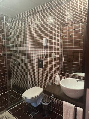 Ein Badezimmer mit Toilette, Waschbecken und Duschbereich.