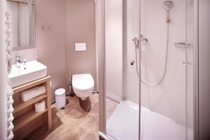 A modern bathroom with a glass shower enclosure, a white sink, and a toilet. - Alexander Von Humboldt Das Schiff (Bremen)