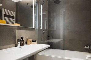 A modern bathroom with a glass-enclosed shower, a white sink, and a bathtub. - Dreams Hotel Cittv Studi (Milan)