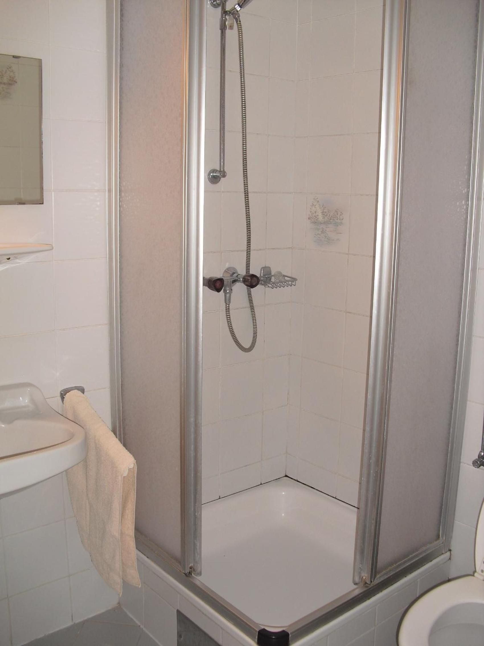 Ein Badezimmer mit Duschkabine, Waschbecken und Toilette.
