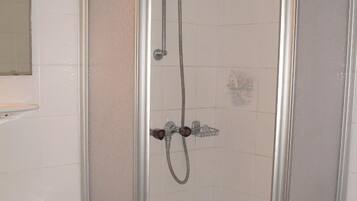 Ein Badezimmer mit Duschkabine, Waschbecken und Toilette.