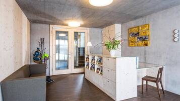 Un espace d’accueil comprenant un bureau en bois, une vitrine et une horloge murale.