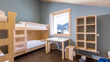 Une chambre avec un lit superposé, un bureau et une fenêtre.