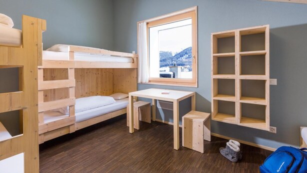 A bunk bed room with a desk and a window. - Nova Casa Spinatscha Sedrun (Tujetsch)