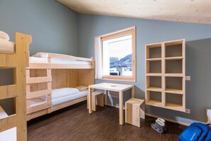 Dormitorio con literas, un escritorio y una ventana.