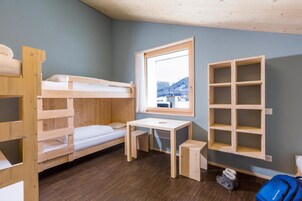 Dormitorio con literas, un escritorio y una ventana.