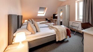 Une chambre d’hôtel comprenant un lit, un bureau, une chaise, un téléviseur et une armoire.