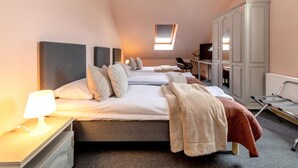 Une chambre d’hôtel avec un grand lit, un bureau avec une lampe, une armoire et un téléviseur.