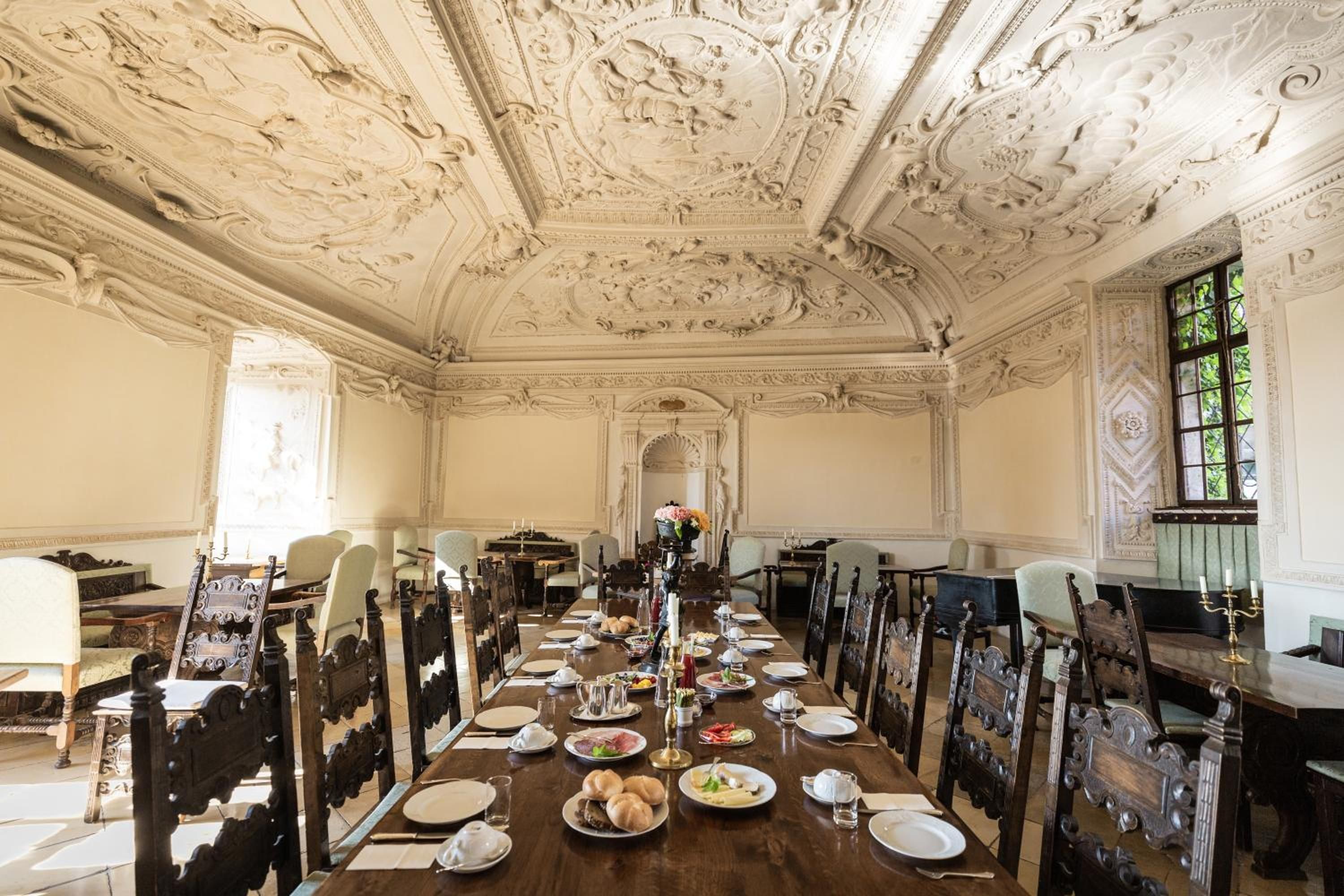 Ein formeller Speisesaal mit aufwendiger Decke und klassischer Möbel.